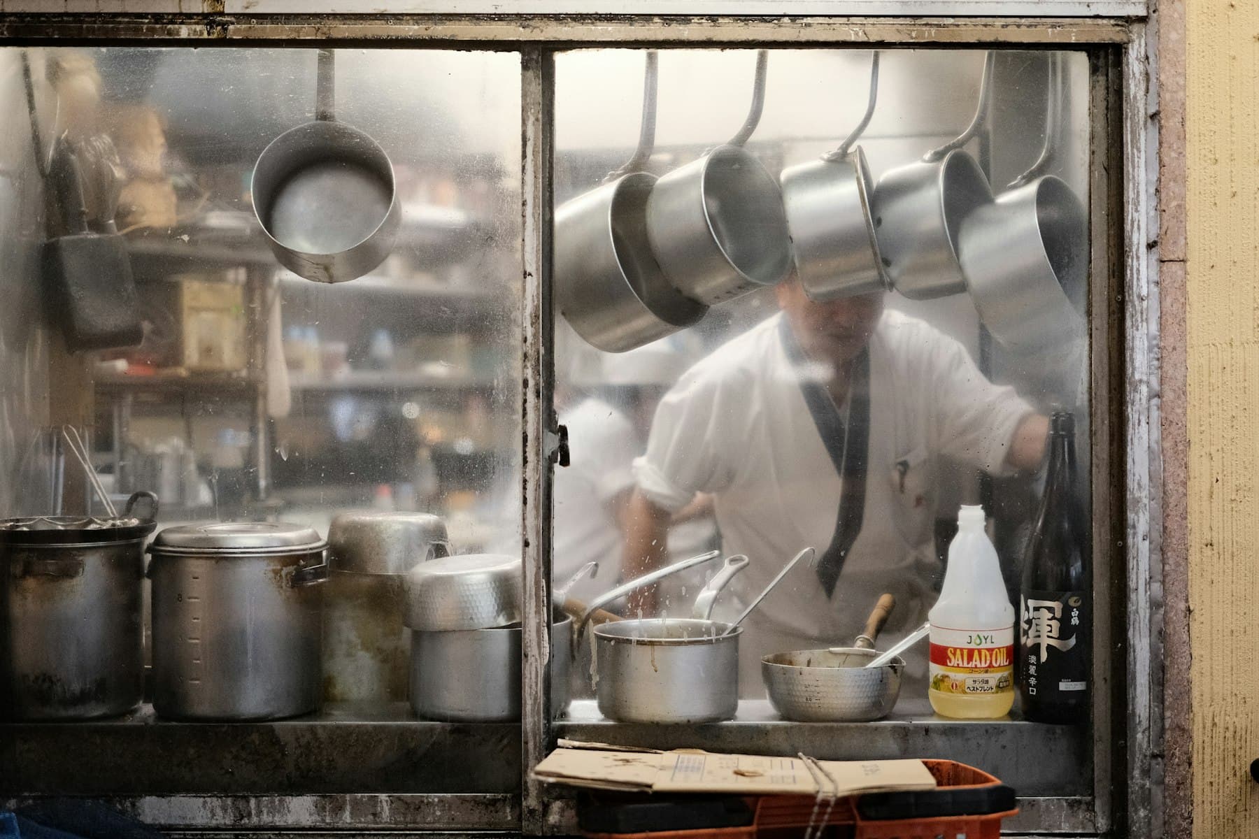 A cook working behind the pass in a restaurant kitchen